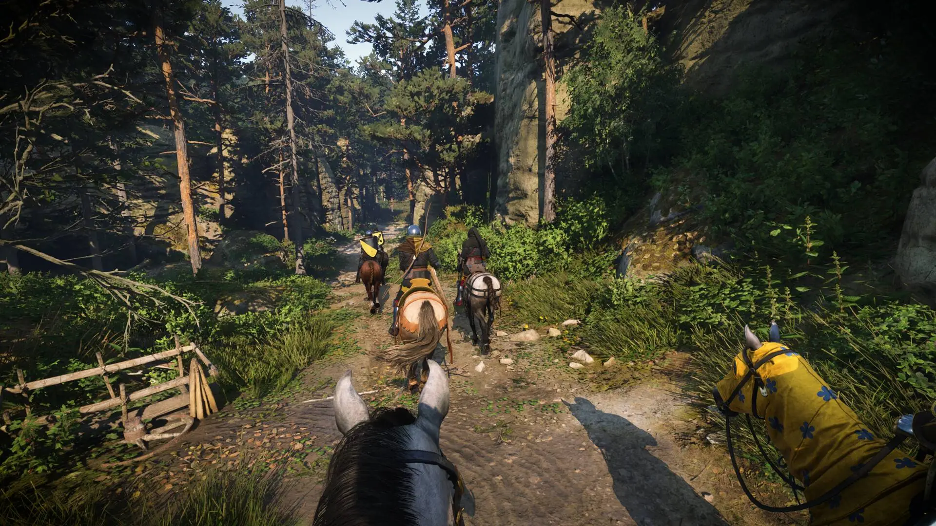 A party of riders on horseback following a forest track in Kingdom Come: Deliverance II